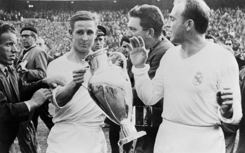 Alfredo Di Stefano holding the inaugural UEFA Champions League trophy, as his Real Madrid side won the 1955 tournament.