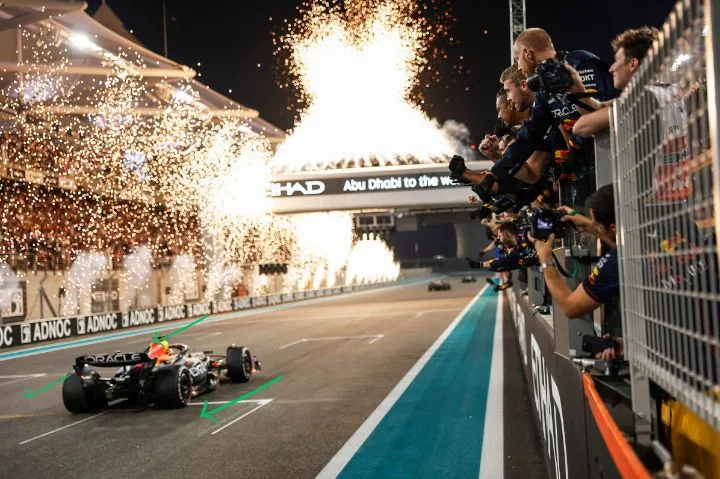 2026 Formula 1 Regulation blog - downforce on F1 car as Max Verstappen races at Yas Marina Circuit, crossing the finishing line with fireworks going off