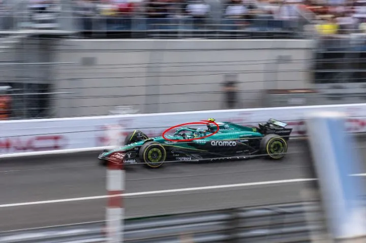 Fernando Alonso driving the Aston Martin around Circuit de monaco, witha circle around the halo on the car