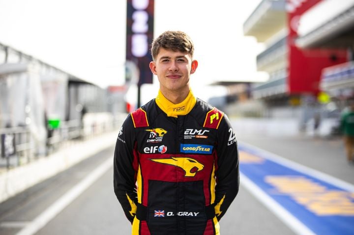 Ollie Gray head shot in race suit 