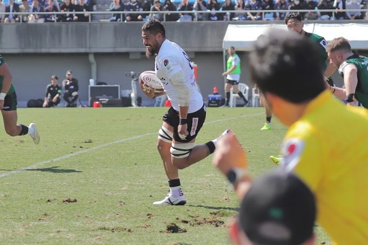 Amata Fakatava carrying the ball across the pitch for Japan Rugby