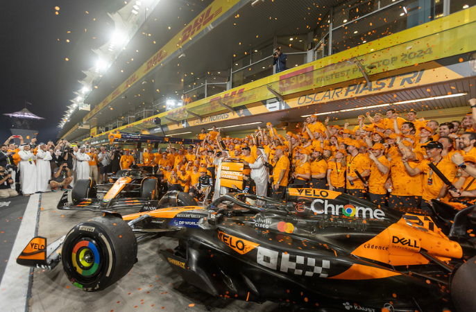 McLaren Racing is celebrating in the pit lane at Yas Marina Circuit, Abu Dhabi, in front of their cars and team garage